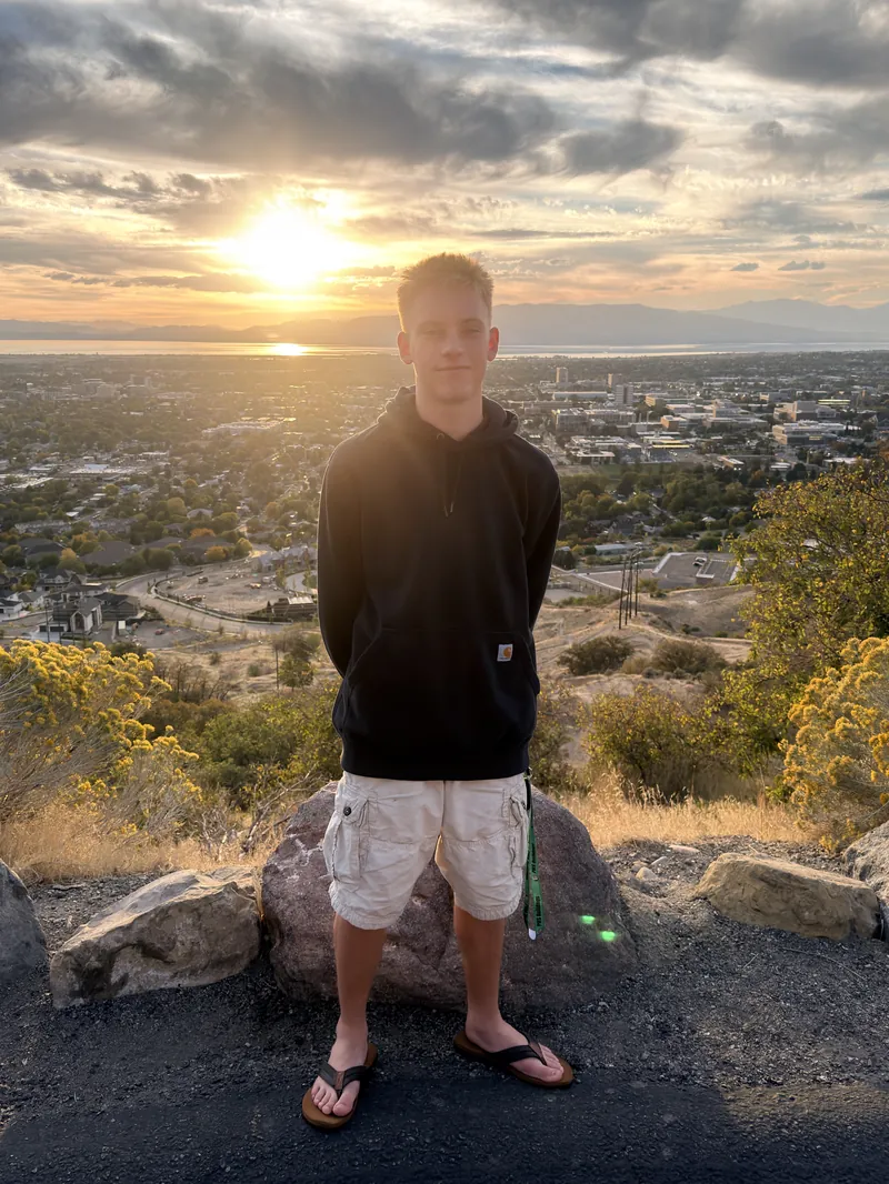 Jake, the founder of MPrints, standing on a hillside at sunset.